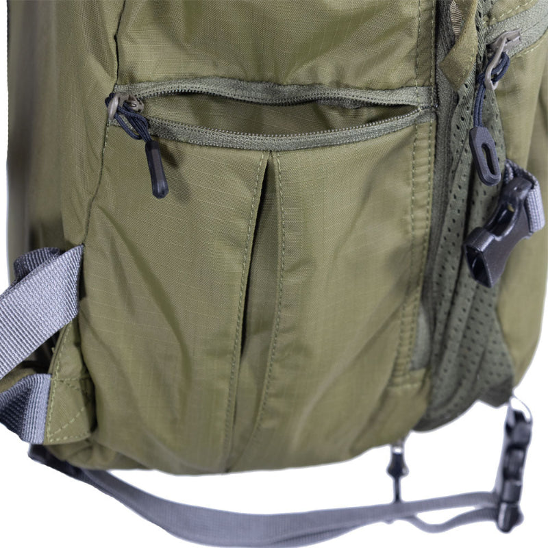 Close-up of a green backpack with zippers and straps on a white background
