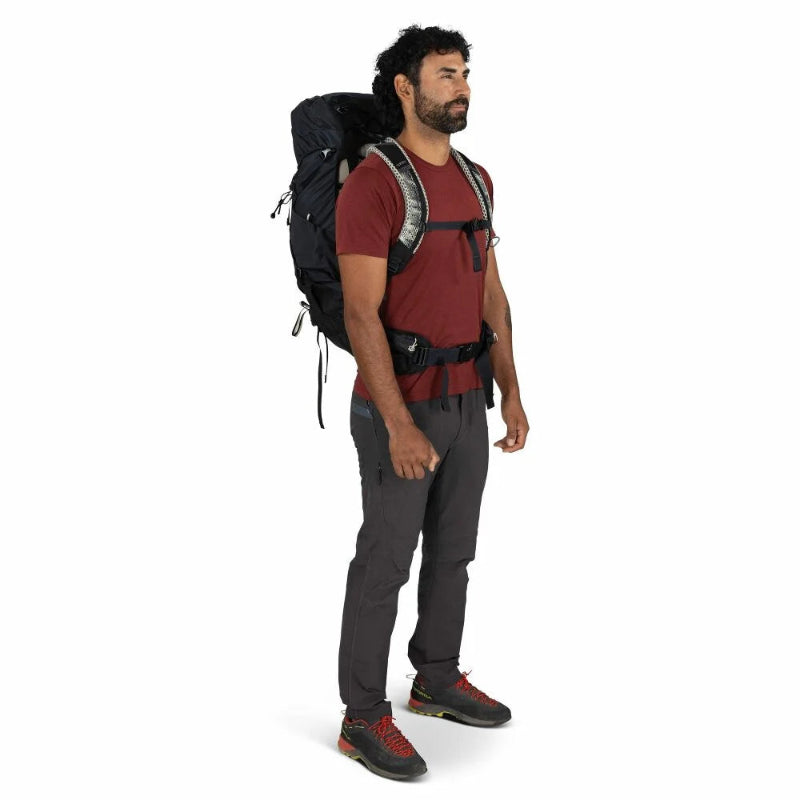 Man wearing a large black backpack on a white background