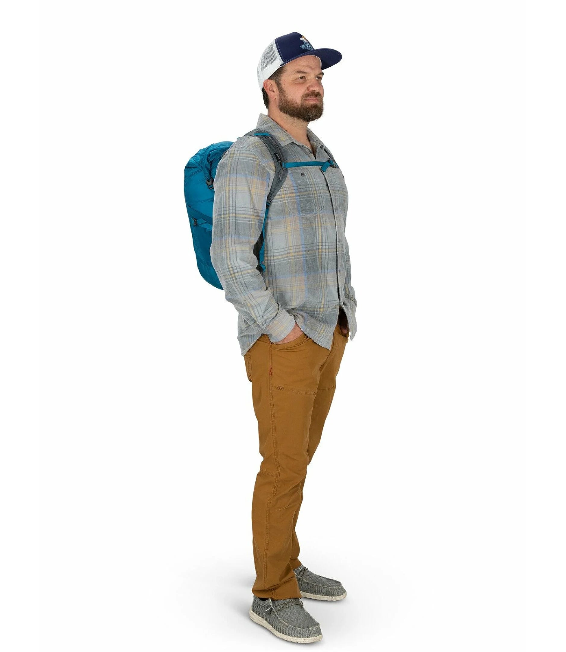 Man wearing a blue Osprey backpack and plaid shirt on a white background