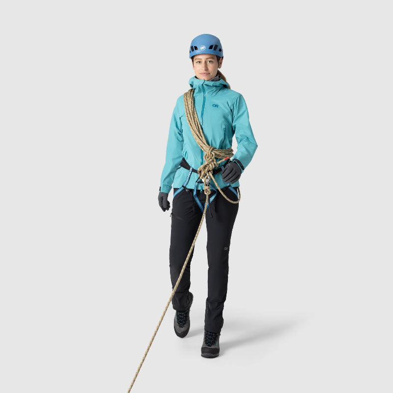 Person wearing a turquoise jacket and black pants with climbing equipment on a white background