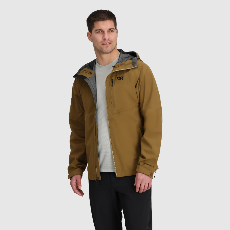 Man wearing a brown jacket with a visible brand logo on a light gray background