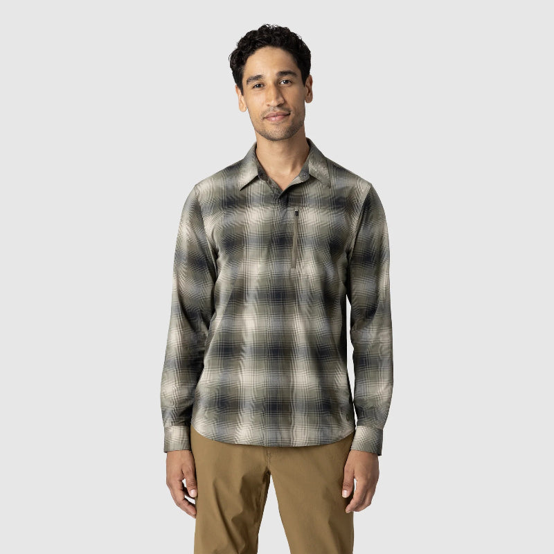 Man wearing a plaid shirt and brown pants on a light gray background