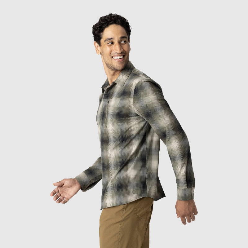Man wearing a plaid shirt and beige pants on a light gray background