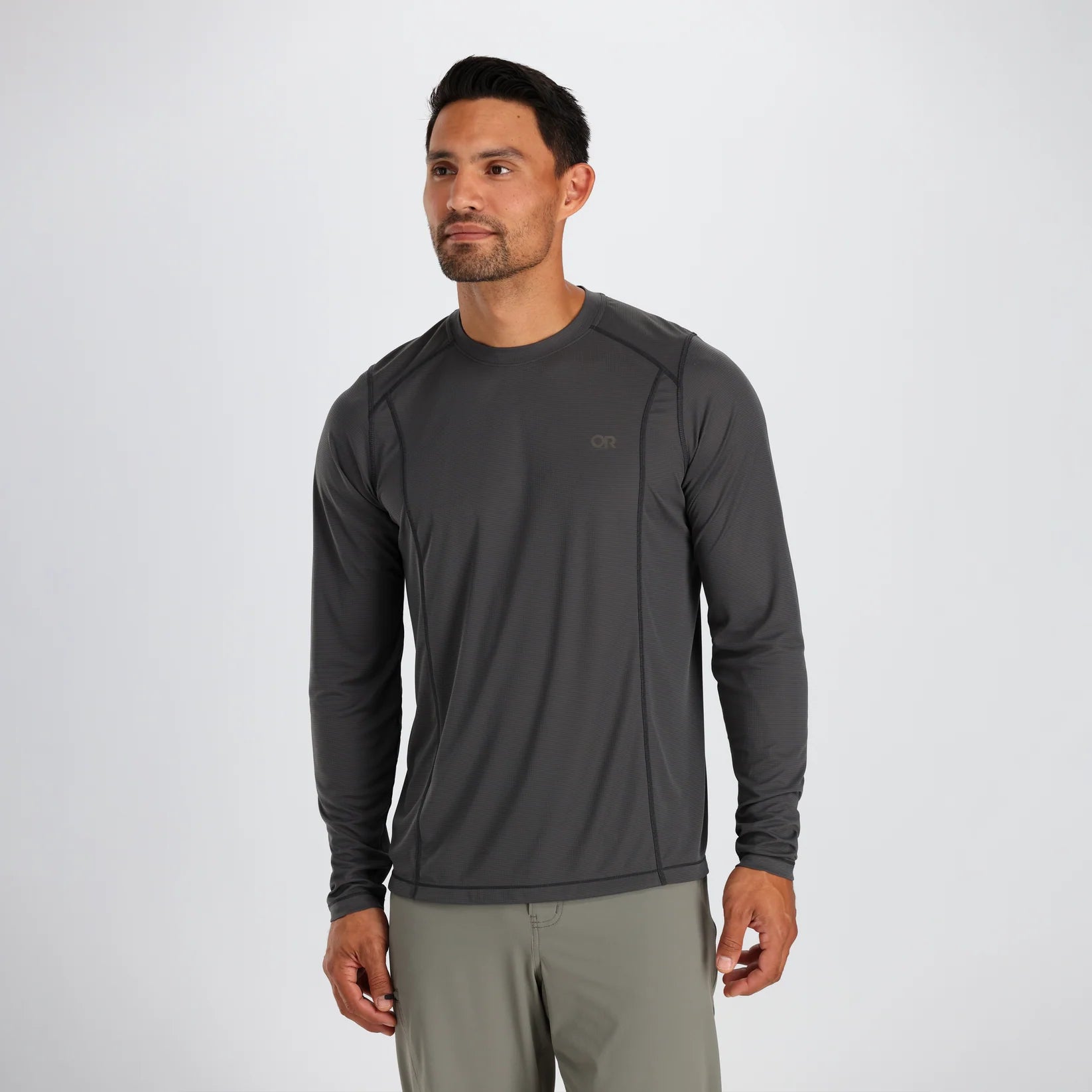 Man wearing a dark gray long-sleeve Outdoor Research athletic shirt on a white background
