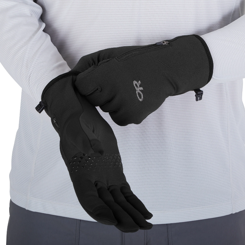 Black gloves worn by a person with a light gray background