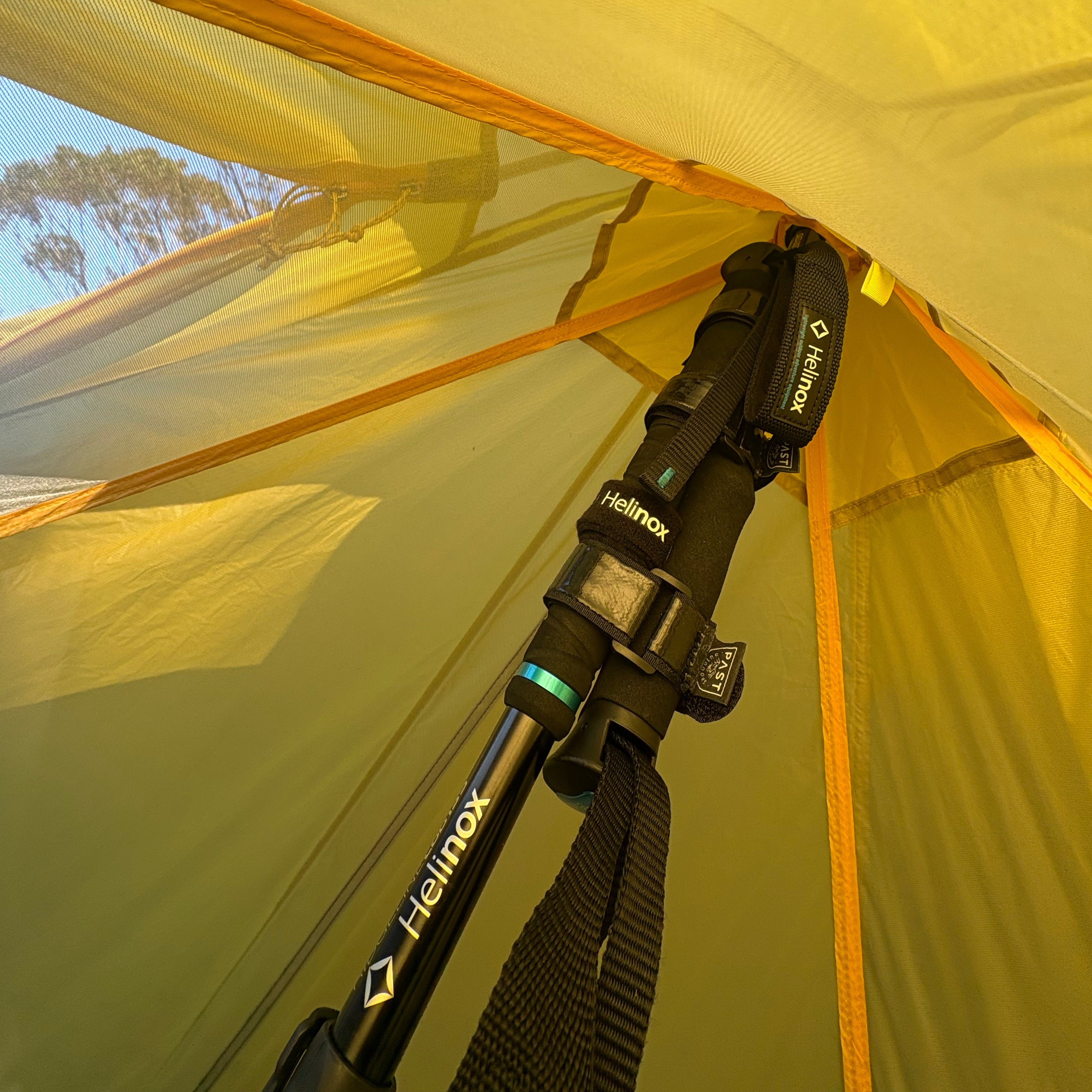 Close-up of a tent pole with Helinox branding against a yellow tent background