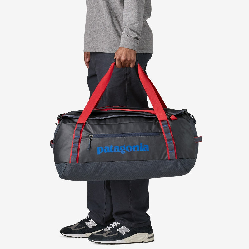 Man carrying the Patagonia Black Hole Duffel 55L with his left hand