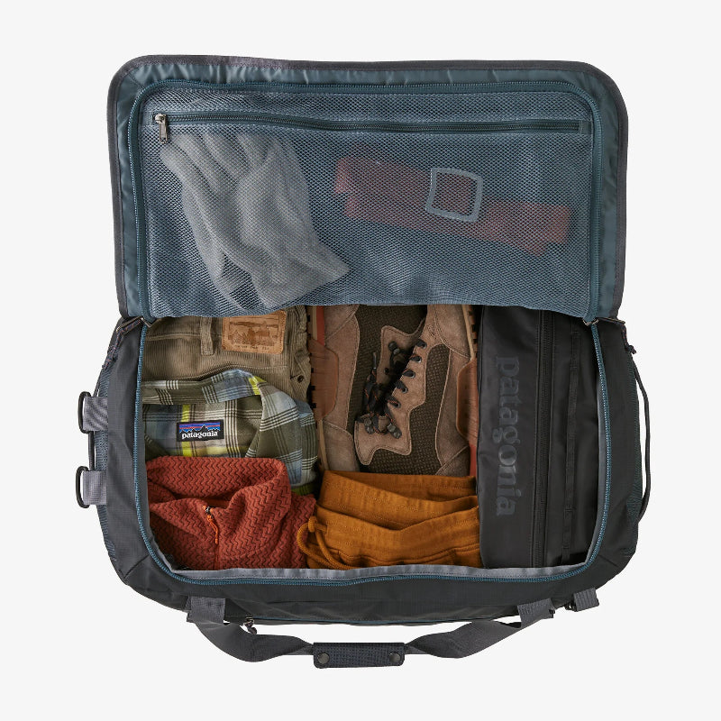 Open backpack with clothes and Patagonia logo on a white background