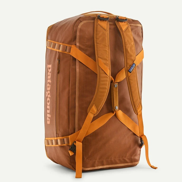 A brown Patagonia backpack shown from the back, featuring orange straps, a vertical Patagonia logo on the side, and a small blue brand tab on the upper right.