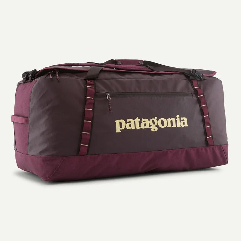 A large Patagonia duffel bag in dark plum and burgundy with a gold Patagonia logo on the front, set against a light off-white background.
