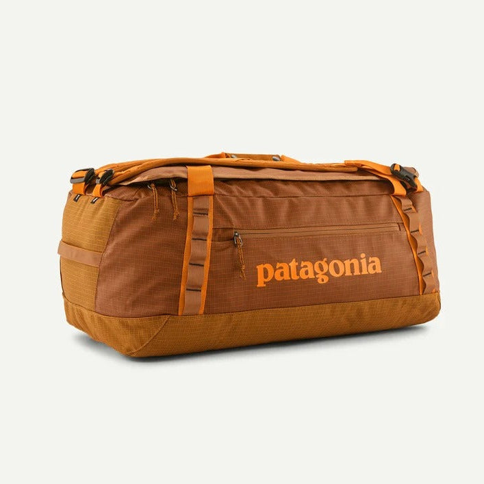 A brown and orange Patagonia duffel bag with the brand name printed in orange on the front, set against a light off-white background.