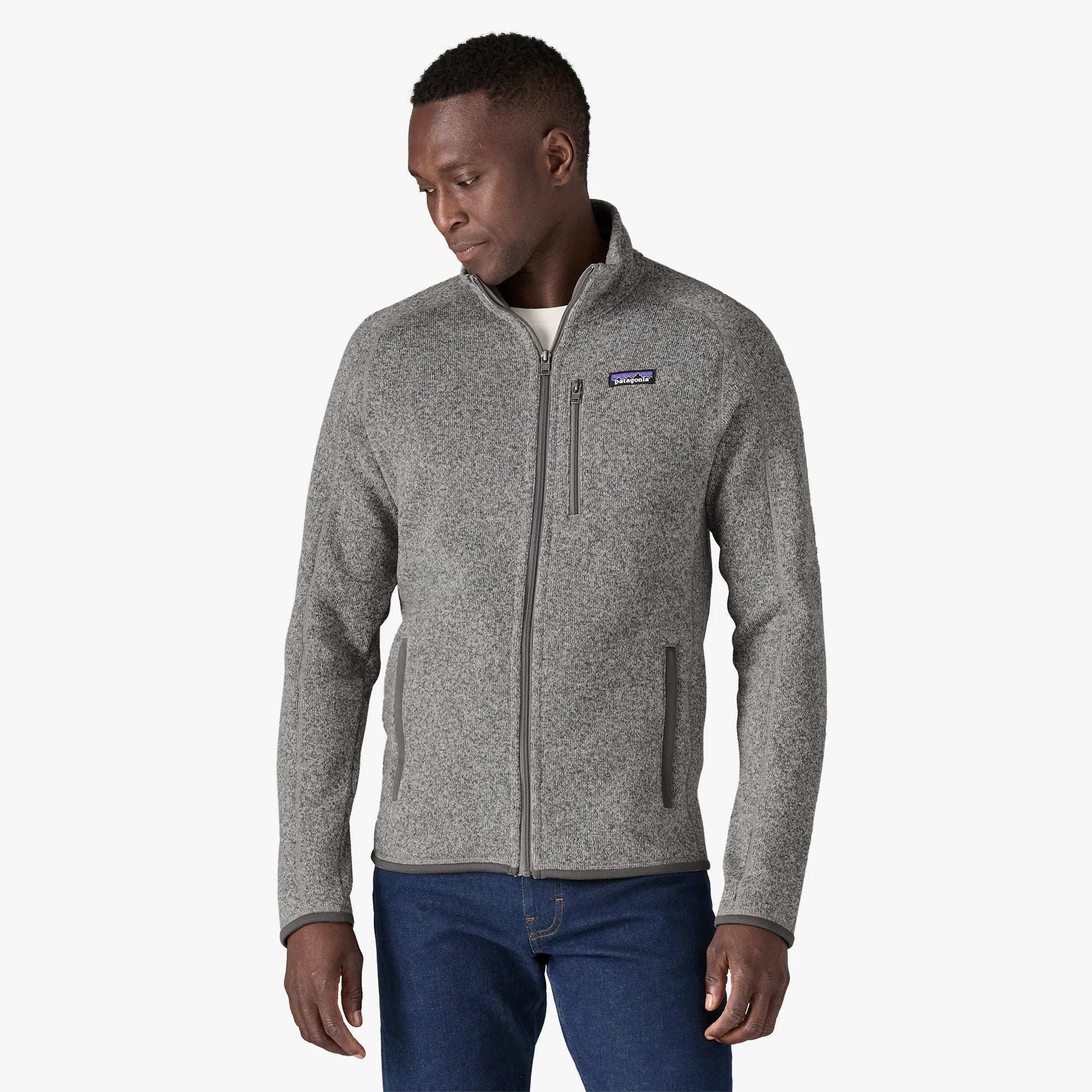 Man wearing a gray fleece Patagonia jacket with a brand logo on a white backgrouind