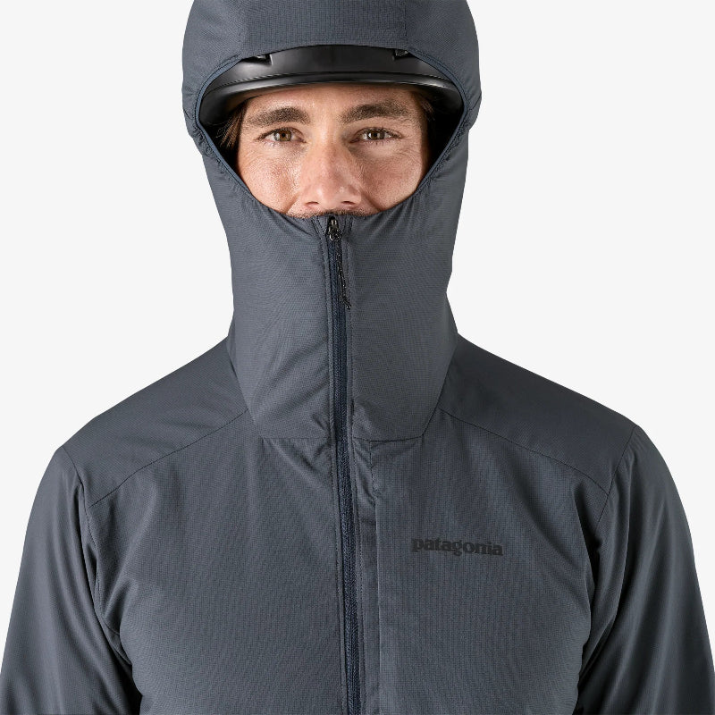 Person wearing a gray Patagonia jacket with a hood on a white background