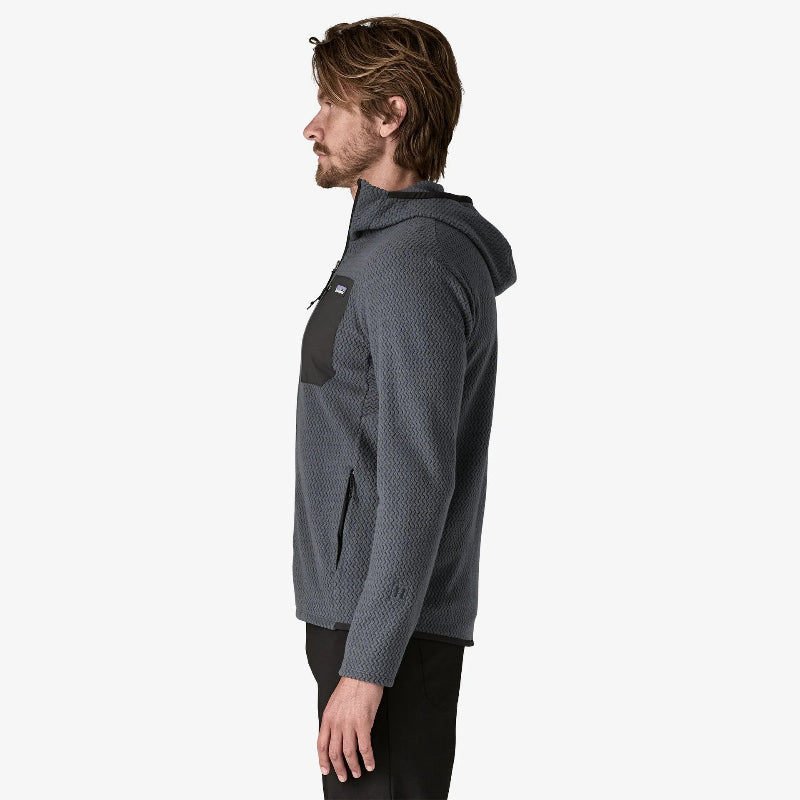 Man standing sideways wearing teh Patagonia Mens R1 Air Fleece Full Zip Hooded Jacket in smolder blue