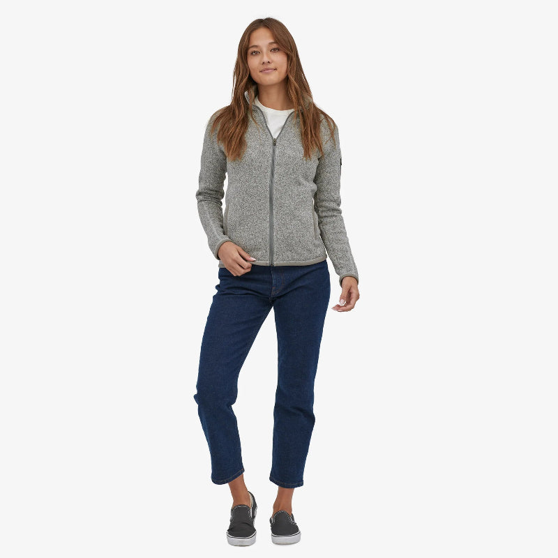Woman wearing the Patagonia Women's Better Sweater Fleece Jacket in birch white stnaidng front on wearing jeans