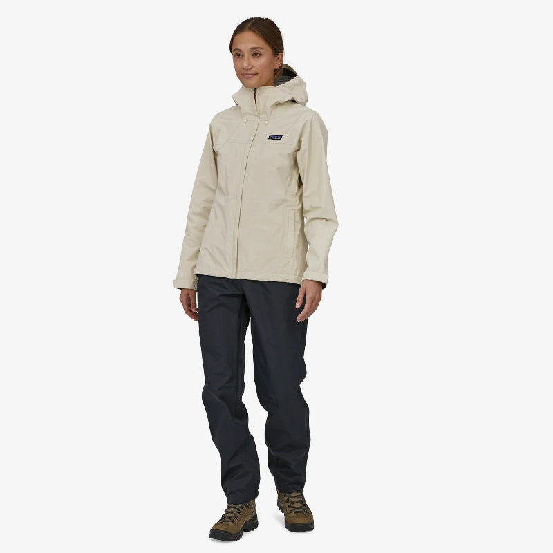 The Patagonia Women's Torrentshell 3L Rain Jacket worn by a woman in hiking boots and black pants