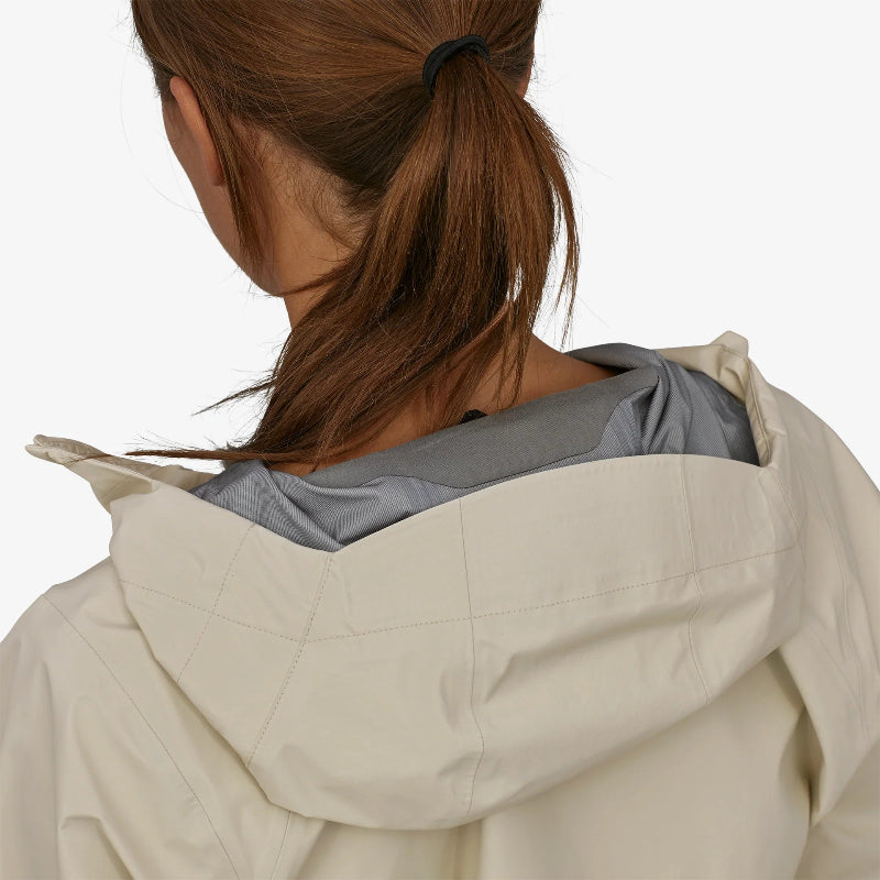 Woman wearing the Patagonia Women's Torrentshell 3L Rain Jacket with her hair tied up showing the hood of the jacket