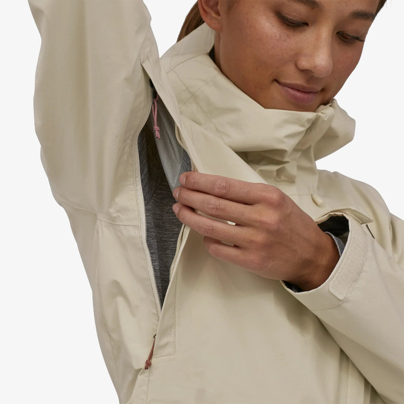 Woman wearing the Patagonia Women's Torrentshell 3L Rain Jacket opening the pit zip on the jacket