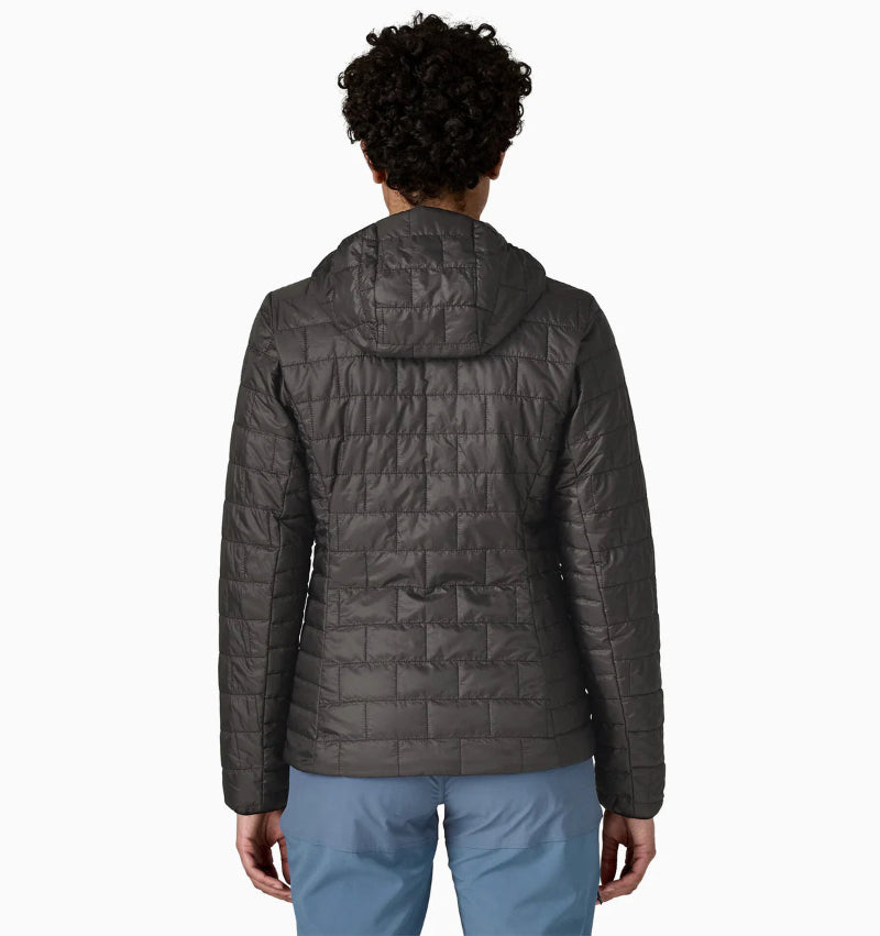Person wearing a black quilted jacket on a white background