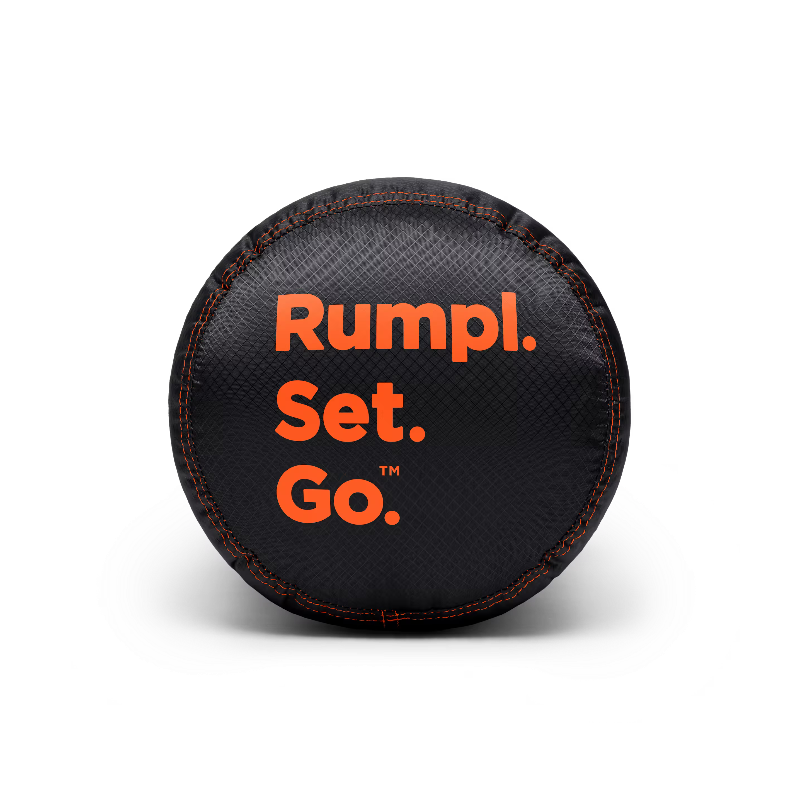 A black textured cylindrical fitness ball with orange text reading 'Rumpl. Set. Go.' on a clean white background.