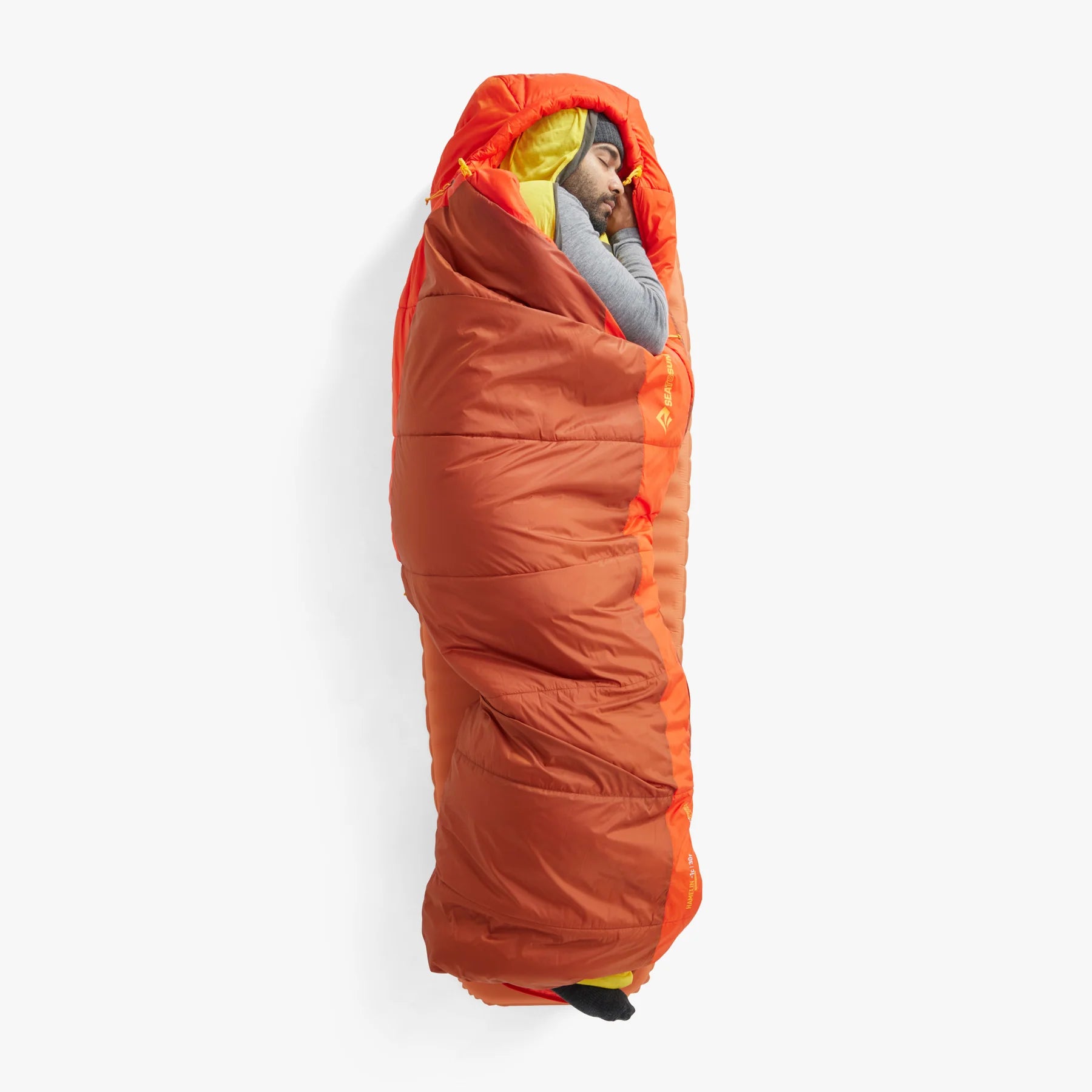 Person sleeping in an orange sleeping bag on a white background