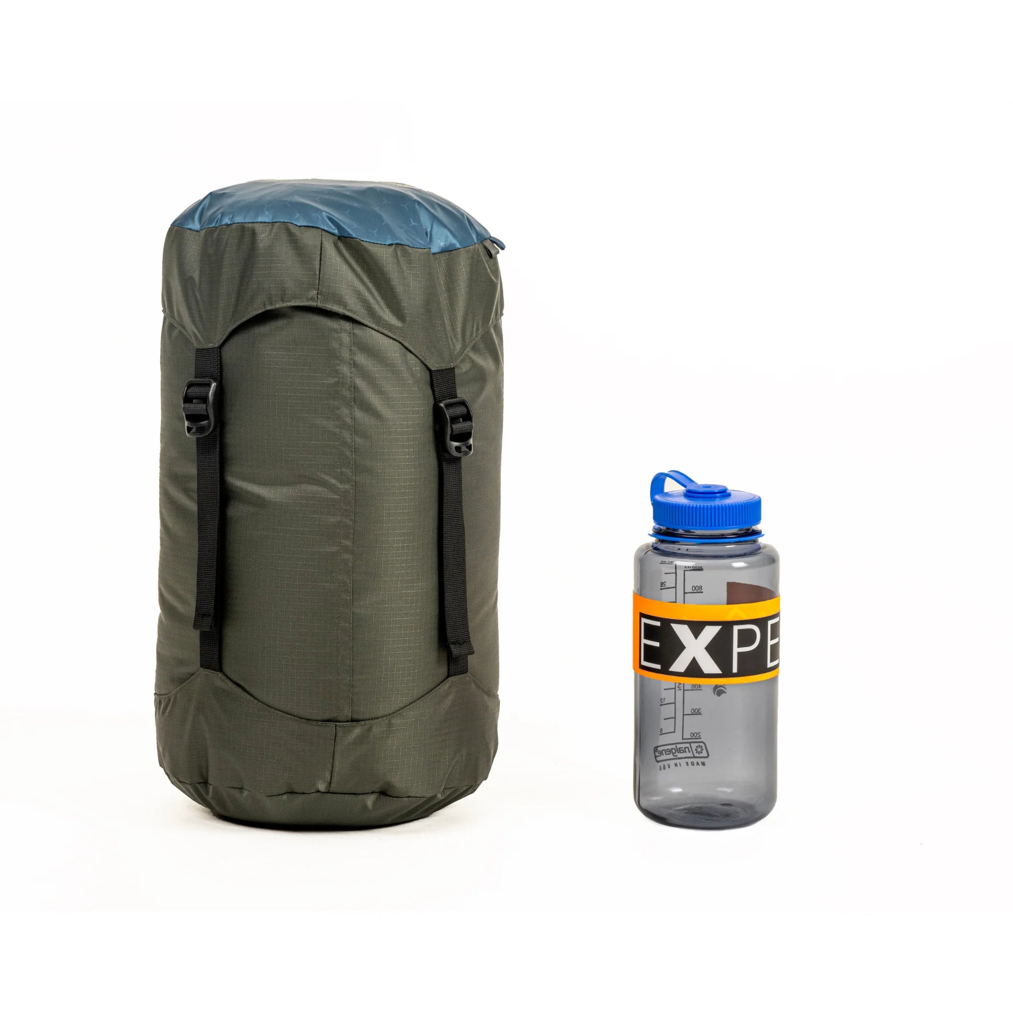 Green lightweight sleeping bag for hiking and gray water bottle with blue cap on a white background