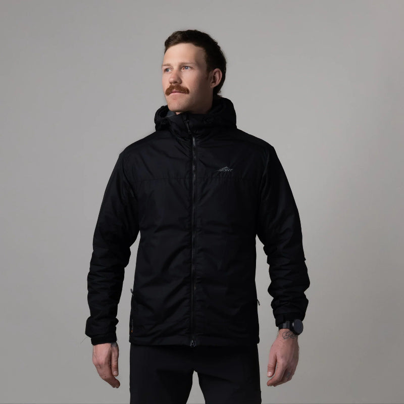 Man wearing a black jacket against a gray background