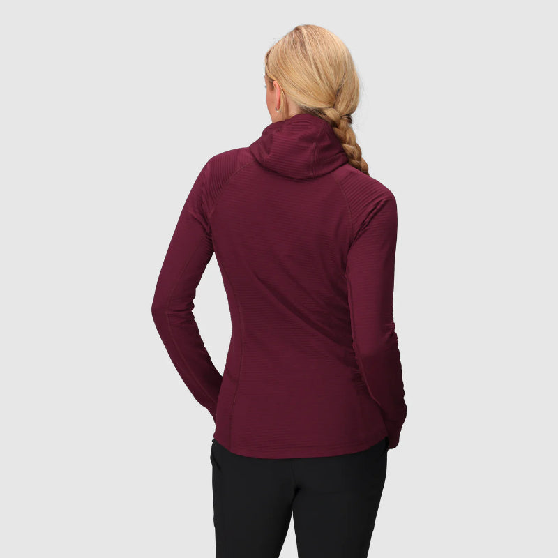 Person wearing a maroon long-sleeve top on a light gray background