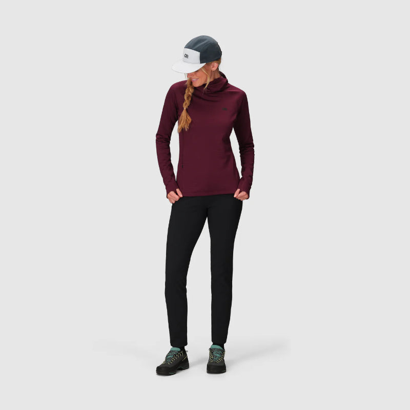 Person wearing a maroon long-sleeve top and black leggings on a light gray background