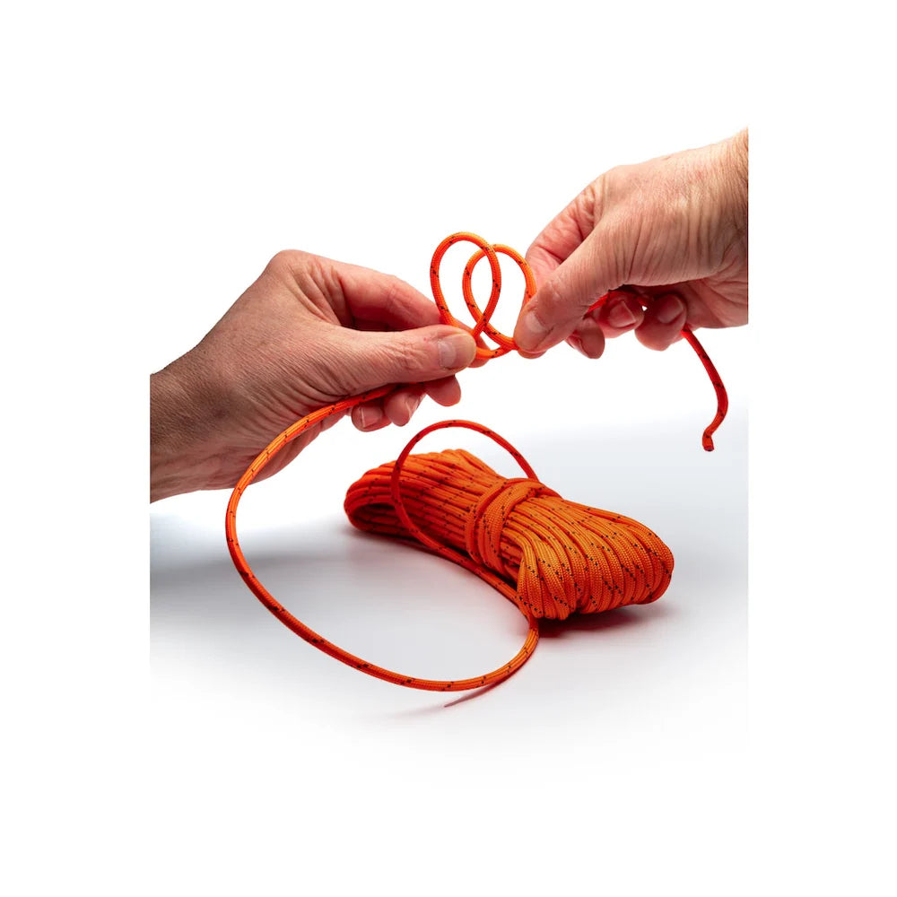 Orange rope being held by two hands on a white background