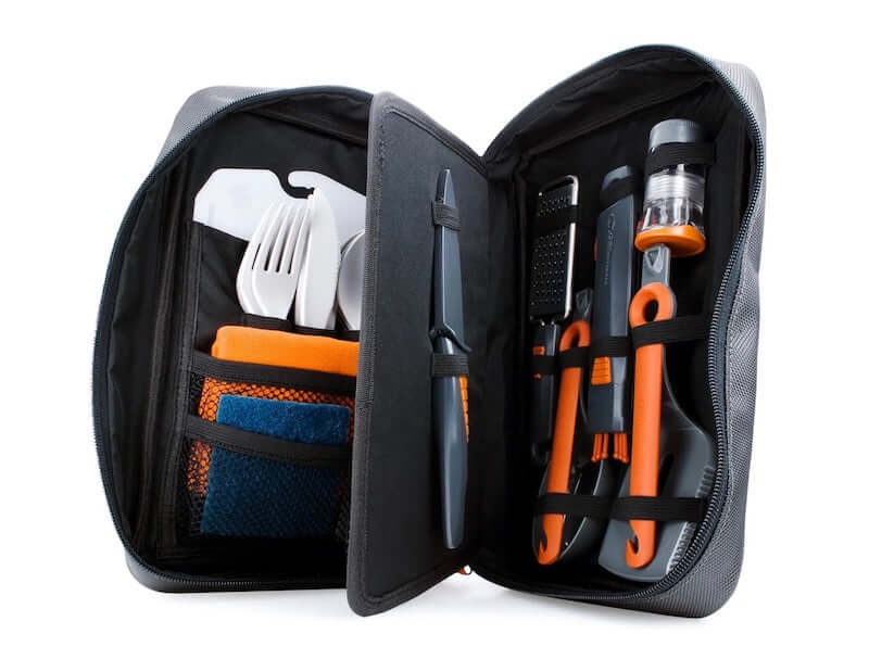 A set of camping kitchen utensils in a black fold out case